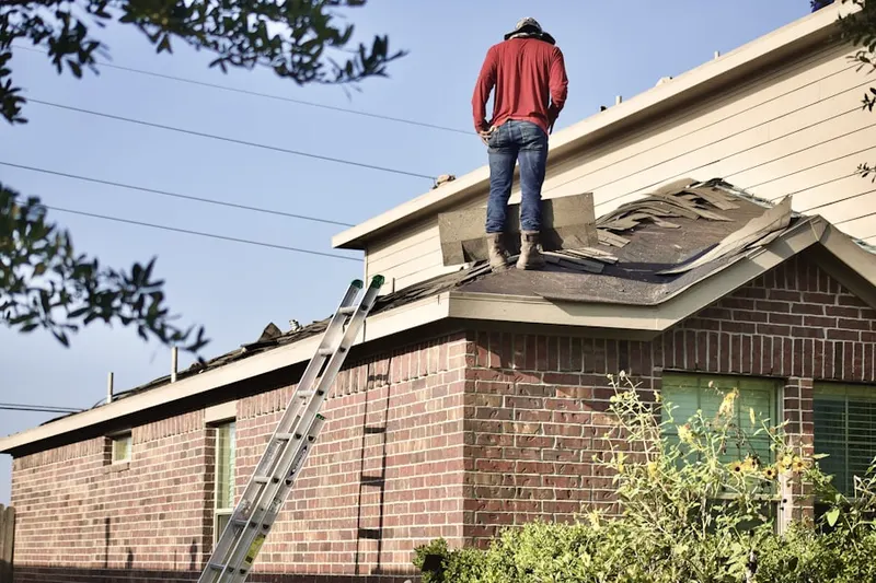 Professional roofer working on a residential roof in University